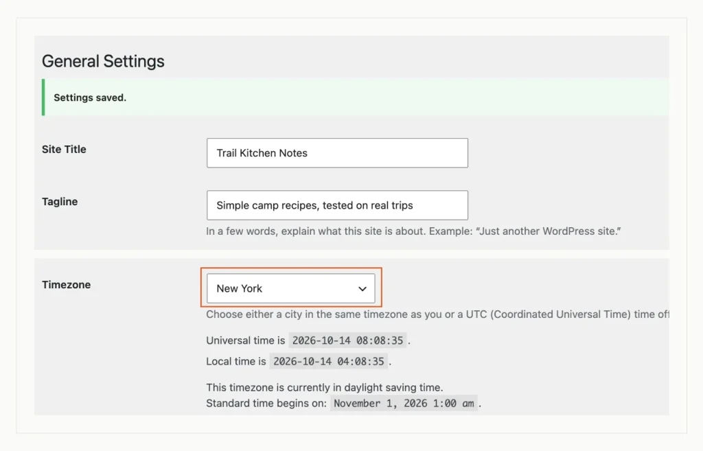WordPress General Settings showing Settings saved, a new site title and tagline, and the timezone set to the city New York, which the screen says is in daylight saving time.